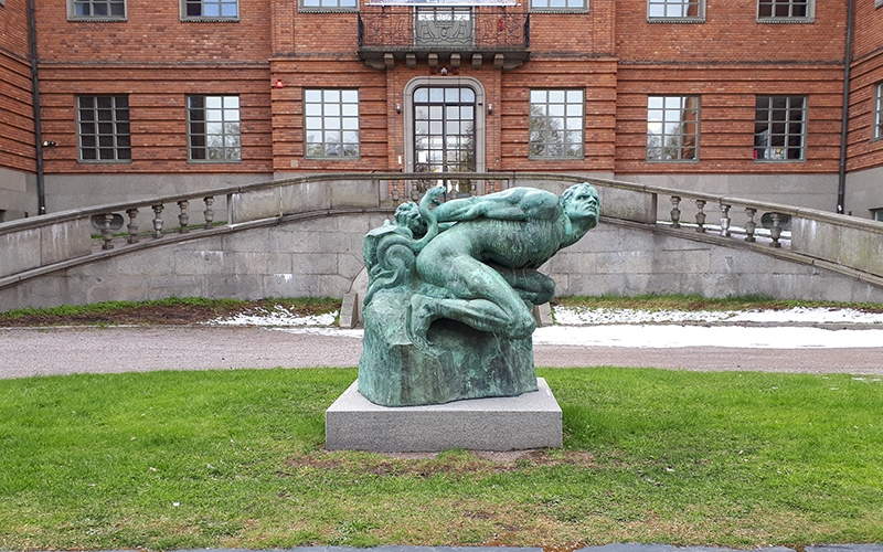 skulptur på gräsmatta framför museibyggnad