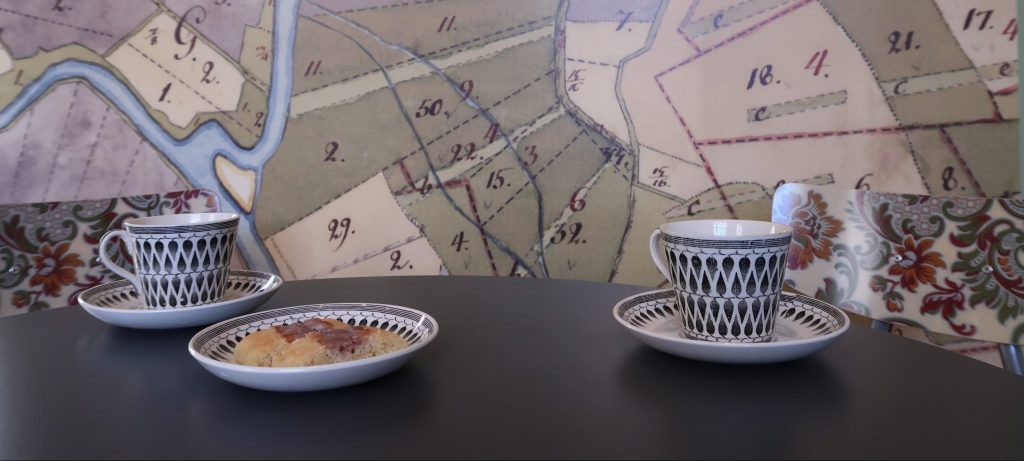 kartmönstrad tapet mönstrade kaffekoppar och syltkakor på svart bord